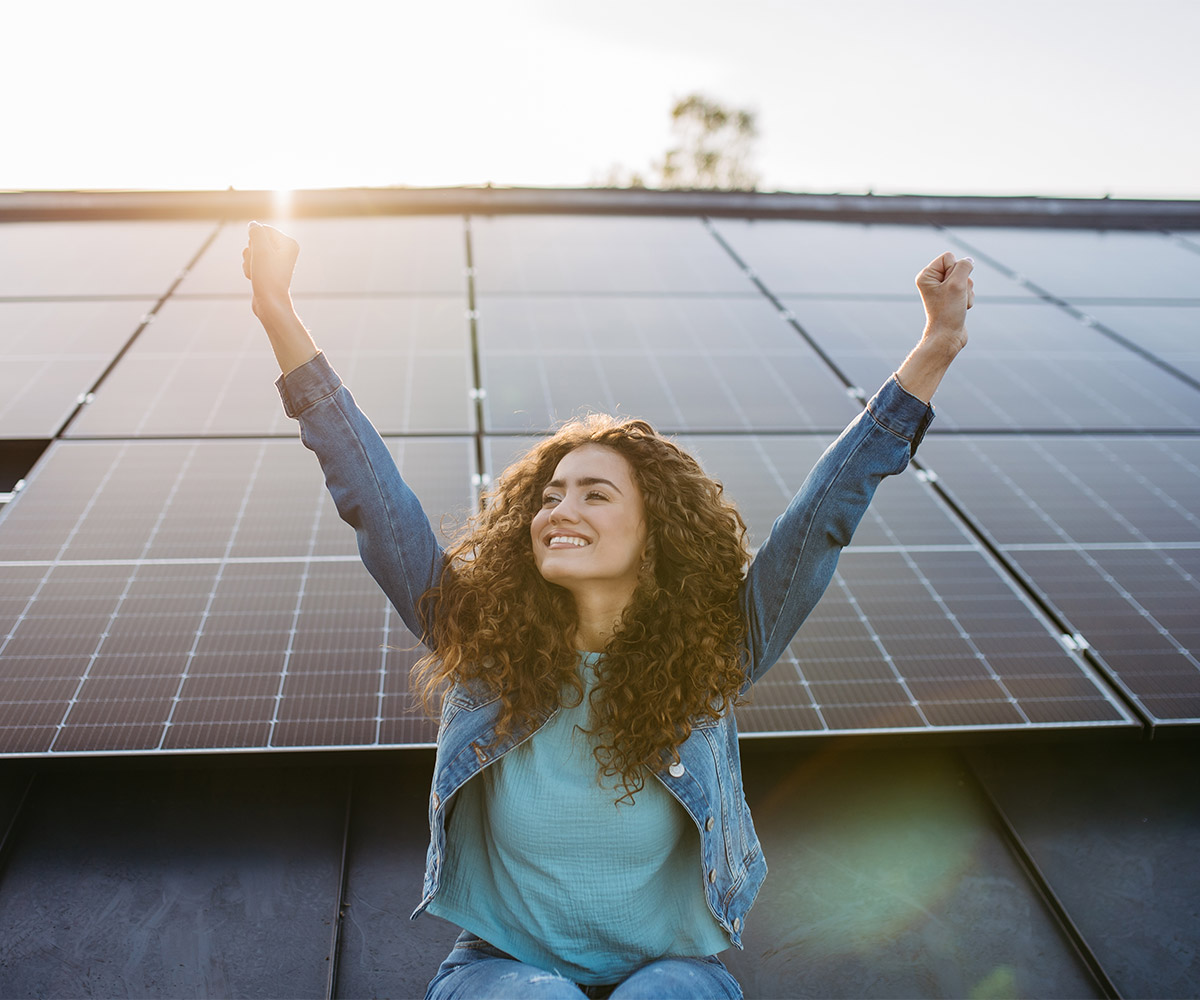 Frau auf einem Dach mit Photovoltaikmodulen